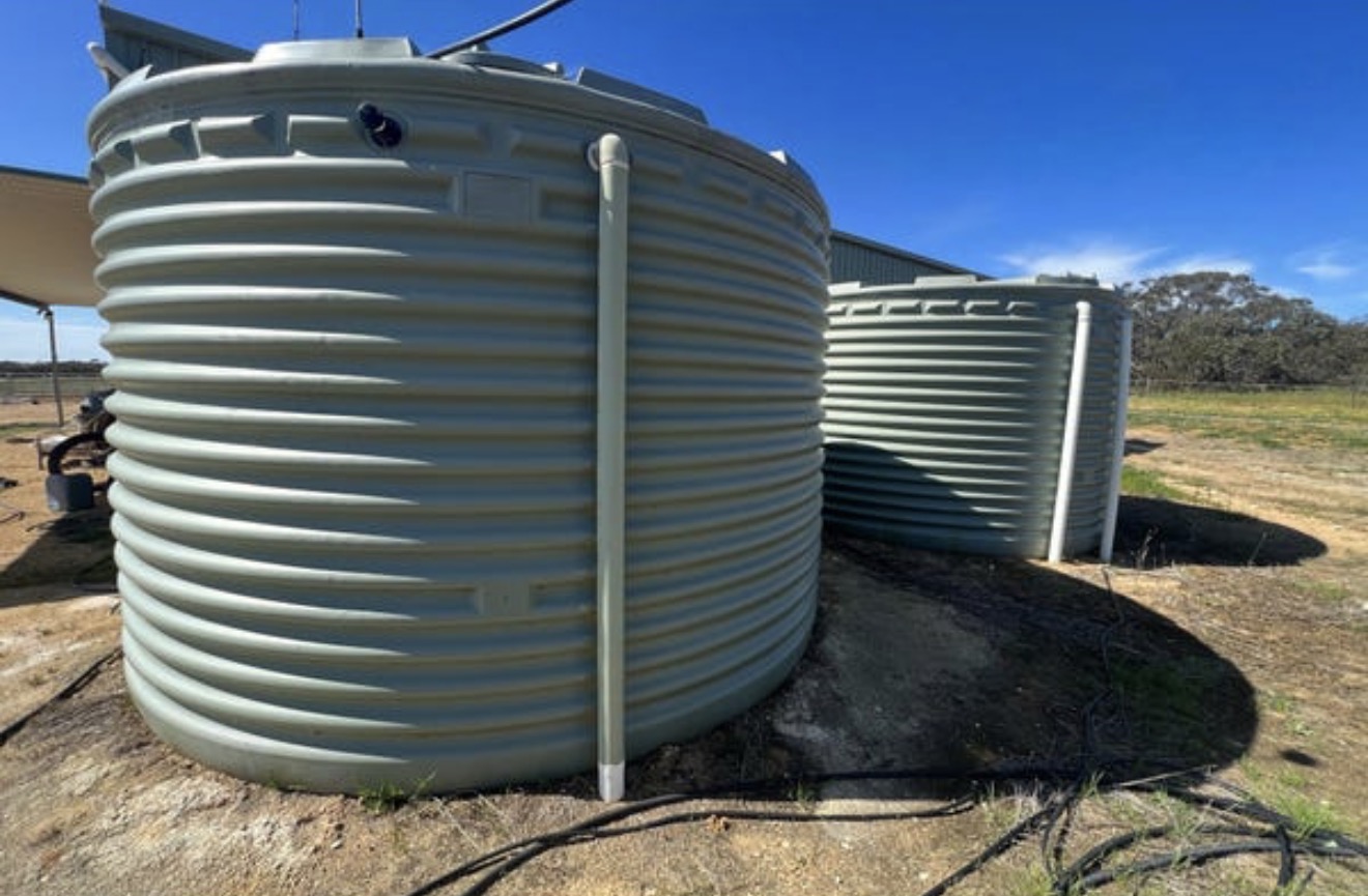 Two 25,000-litre water tanks beside the barn